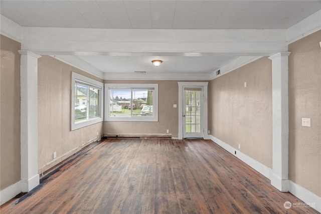 empty room with dark hardwood / wood-style flooring and ornate columns