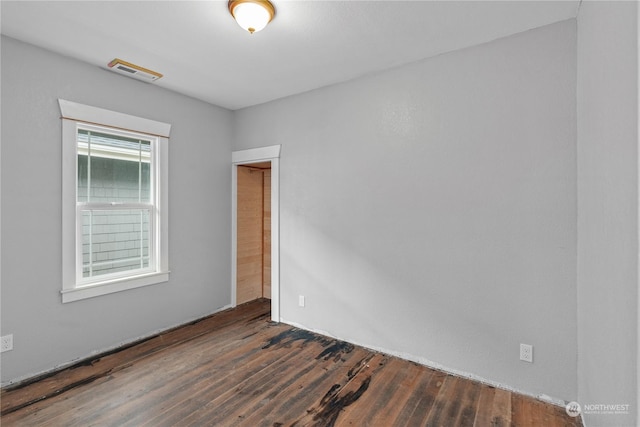 unfurnished room with dark wood-type flooring