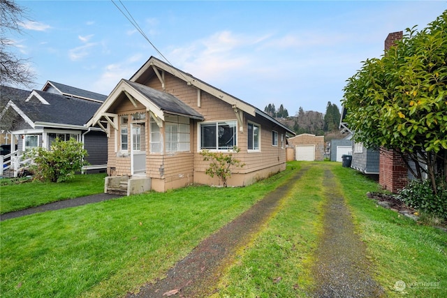 view of front of property featuring an outbuilding, a front yard, and a garage