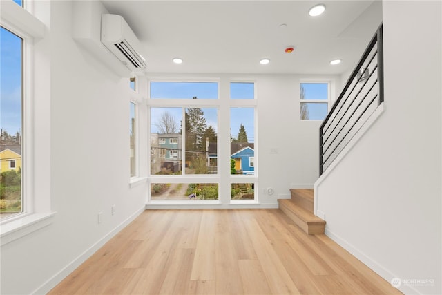 interior space featuring a wall unit AC and light hardwood / wood-style flooring