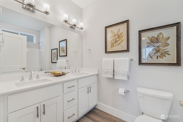 bathroom featuring hardwood / wood-style floors, vanity, toilet, and a shower