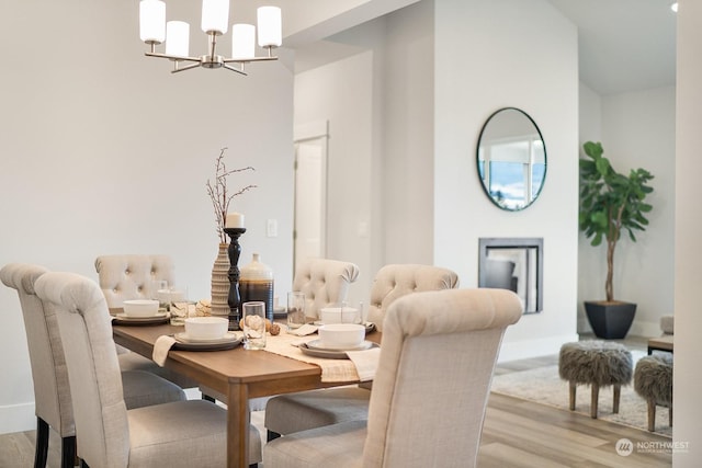 dining area featuring a notable chandelier and light wood-type flooring