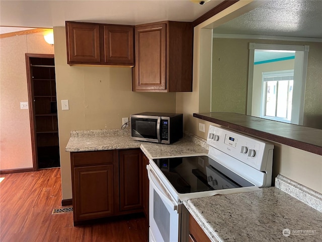 kitchen featuring electric range, crown molding, and dark wood-type flooring