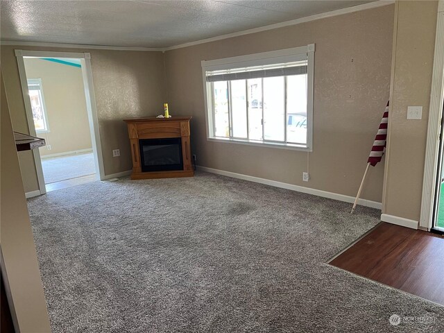 unfurnished living room with carpet, a textured ceiling, and ornamental molding