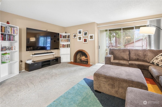 living room with a textured ceiling, carpet floors, and a fireplace