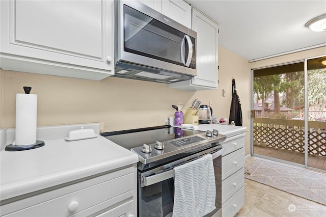 kitchen featuring light countertops, white cabinets, light tile patterned floors, and appliances with stainless steel finishes