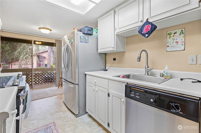 kitchen with a sink, appliances with stainless steel finishes, white cabinets, and light countertops