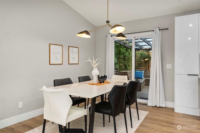 dining space featuring light hardwood / wood-style floors and vaulted ceiling