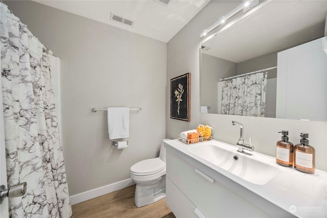 bathroom with a shower with shower curtain, vanity, hardwood / wood-style flooring, and toilet