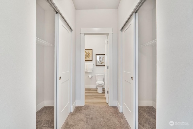 hallway featuring light colored carpet