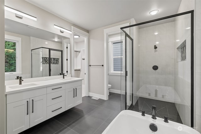 bathroom with tile patterned flooring, a shower with door, vanity, and toilet