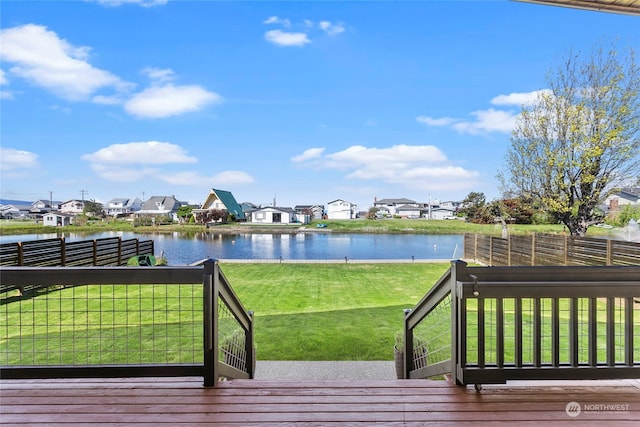 wooden terrace with a lawn and a water view