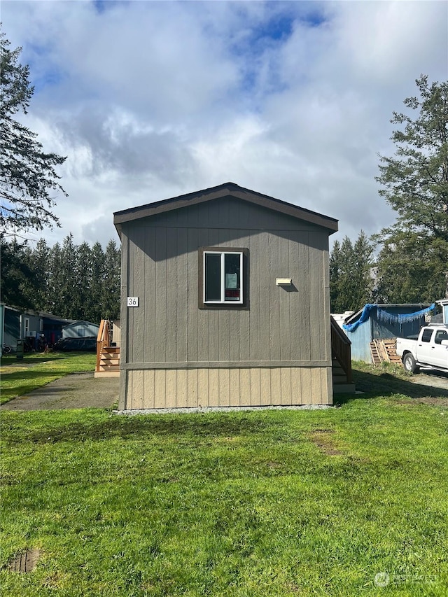 view of property exterior featuring a storage unit and a lawn