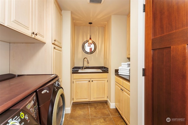 clothes washing area featuring separate washer and dryer, sink, cabinets, and dark tile patterned flooring