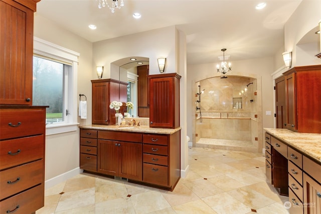 bathroom featuring tile patterned flooring, vanity, an enclosed shower, and an inviting chandelier