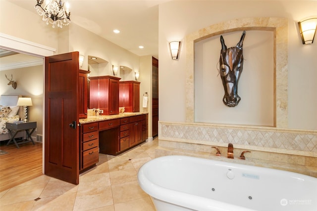 bathroom featuring a washtub, an inviting chandelier, tile patterned flooring, vanity, and ornamental molding