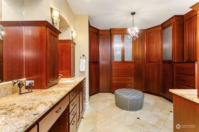 bathroom with a chandelier, vanity, and tile patterned floors