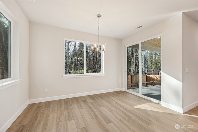 unfurnished dining area with hardwood / wood-style flooring and an inviting chandelier