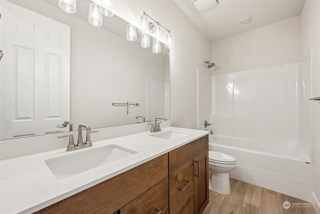 full bathroom featuring shower / washtub combination, toilet, hardwood / wood-style floors, and vanity