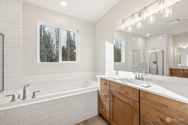 bathroom with vanity, hardwood / wood-style floors, and plus walk in shower