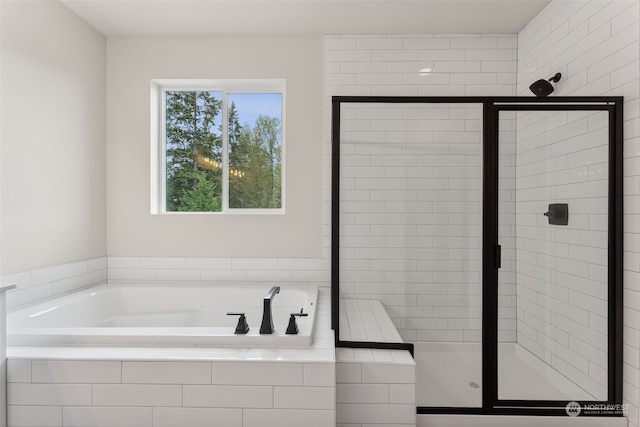 bathroom featuring shower with separate bathtub