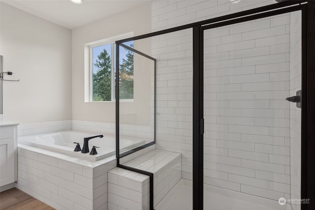 bathroom featuring wood-type flooring, vanity, and independent shower and bath