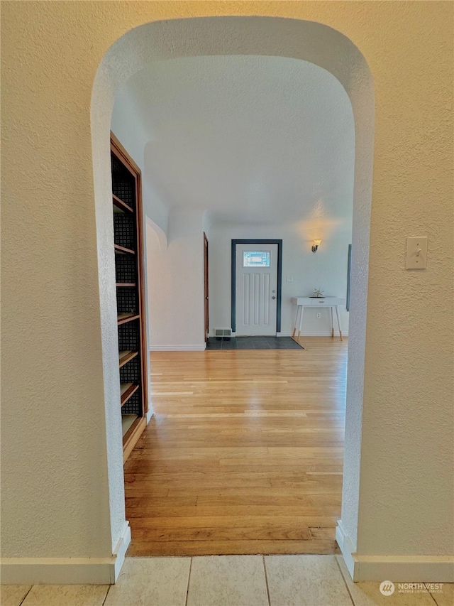 corridor with tile patterned flooring and built in shelves