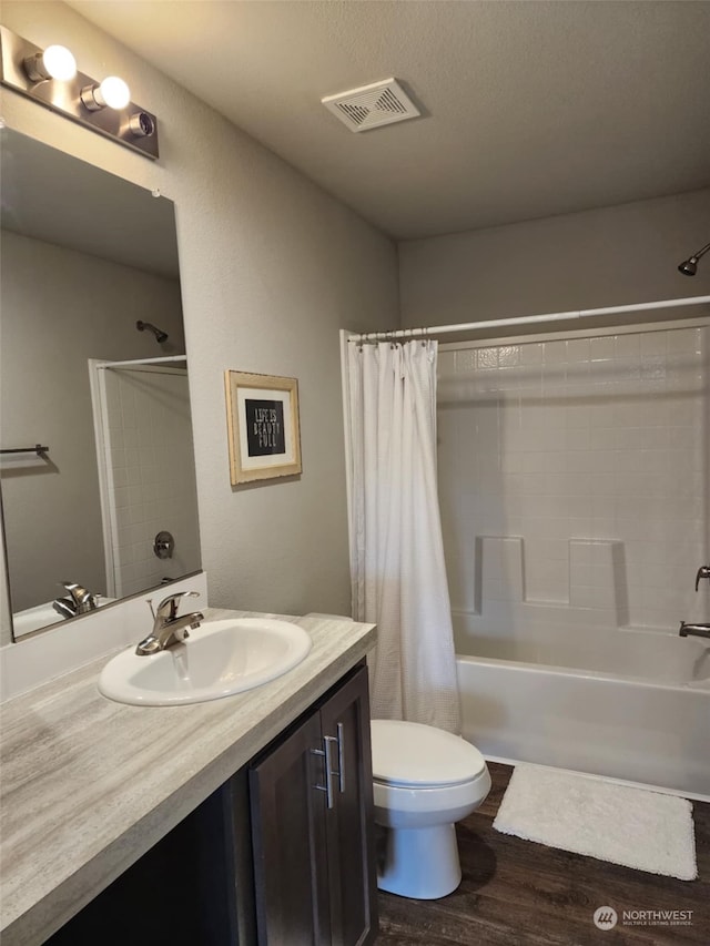 full bathroom with hardwood / wood-style floors, vanity, shower / tub combo with curtain, and toilet