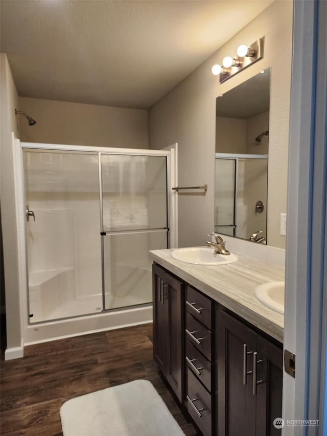 bathroom with vanity, hardwood / wood-style floors, and a shower with door