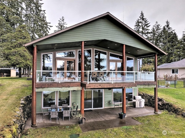 rear view of house with a patio and a lawn