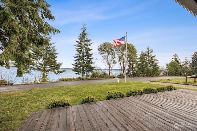 deck featuring a water view and a lawn