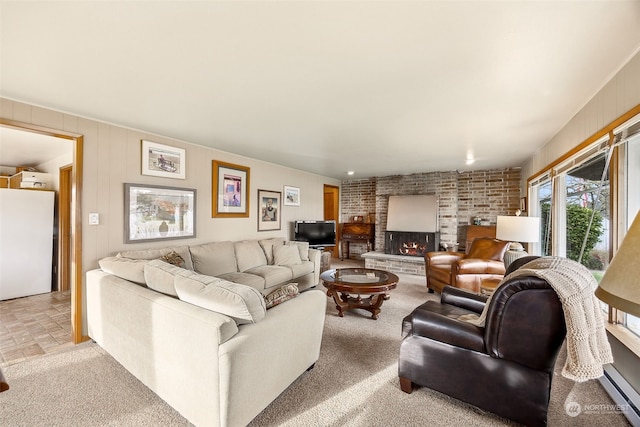 living room featuring a fireplace, light carpet, and a baseboard heating unit