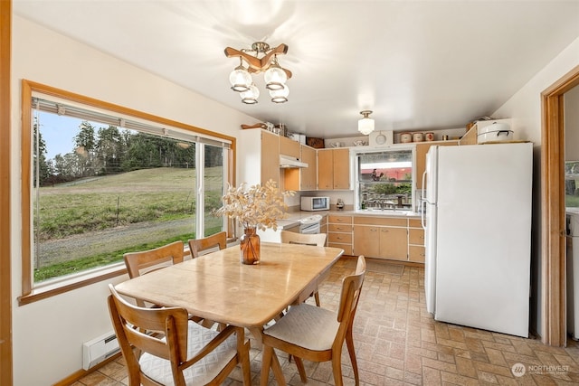 dining room with an inviting chandelier, sink, and a baseboard radiator