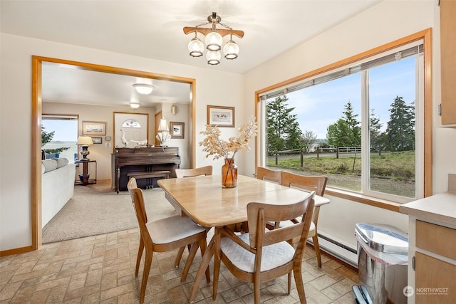 dining room with a baseboard radiator and a chandelier