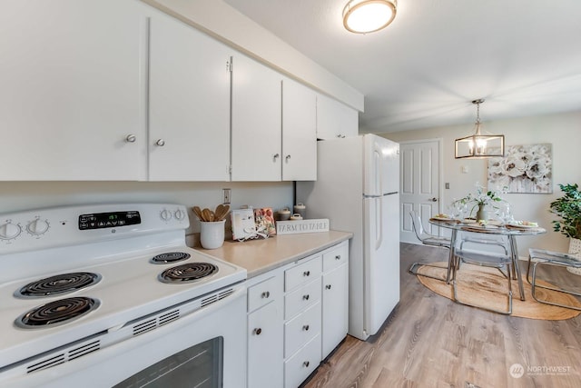 kitchen featuring white appliances, hanging light fixtures, light hardwood / wood-style floors, white cabinetry, and a chandelier