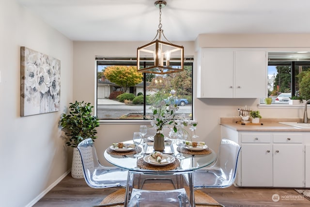 dining space with dark hardwood / wood-style floors, an inviting chandelier, a healthy amount of sunlight, and sink