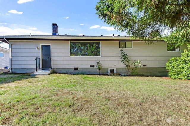 back of property featuring a lawn