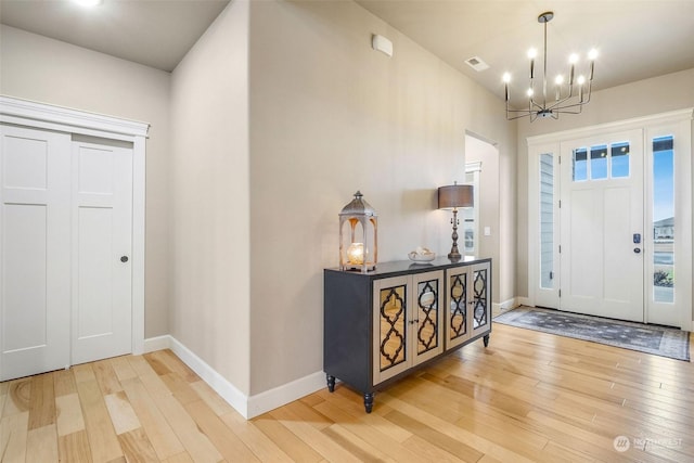 foyer entrance featuring hardwood / wood-style flooring and an inviting chandelier