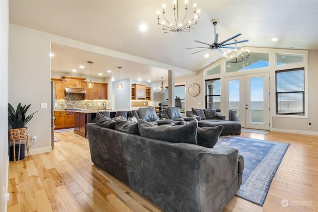 living room with ceiling fan, light wood-type flooring, french doors, and vaulted ceiling