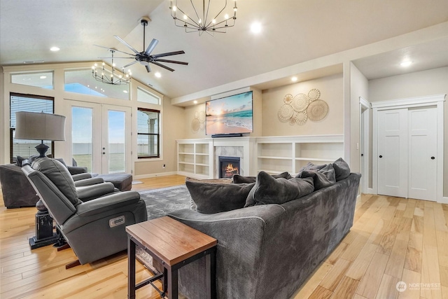 living room featuring vaulted ceiling, light wood-type flooring, french doors, and ceiling fan