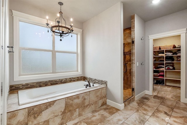 bathroom featuring a notable chandelier and separate shower and tub