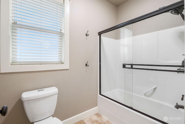 bathroom featuring toilet, combined bath / shower with glass door, and tile patterned flooring