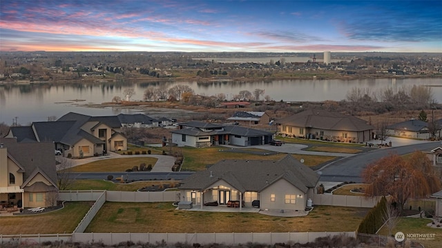 aerial view at dusk featuring a water view