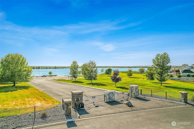 view of property's community featuring a lawn and a water view