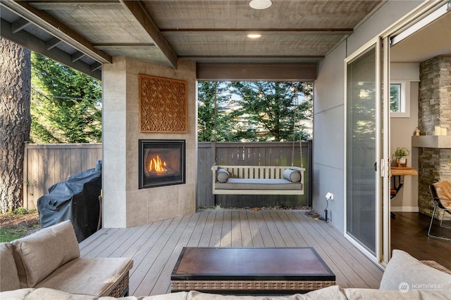 wooden deck featuring a tiled fireplace