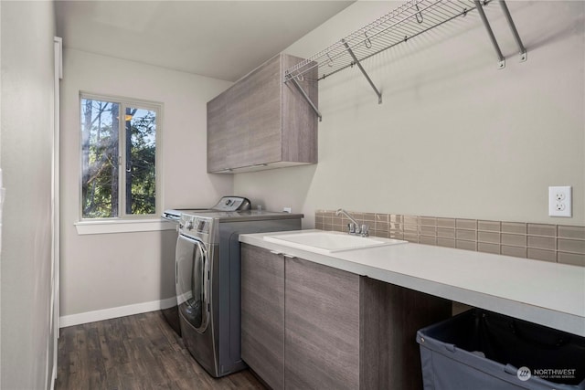 washroom with dark wood-type flooring, cabinets, separate washer and dryer, and sink