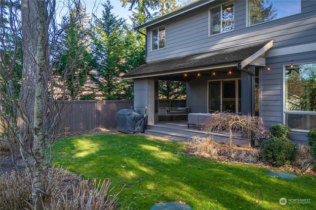 rear view of property with a yard and an outdoor hangout area