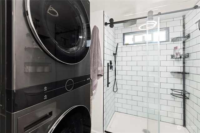 clothes washing area featuring stacked washer and clothes dryer