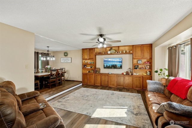 living room featuring a textured ceiling, dark hardwood / wood-style floors, and ceiling fan with notable chandelier