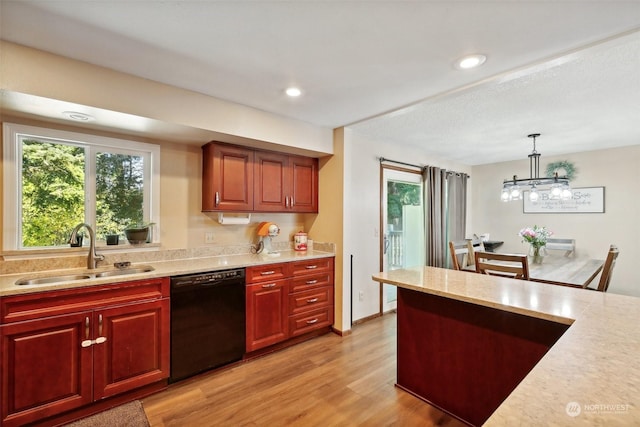 kitchen featuring sink, light hardwood / wood-style flooring, a notable chandelier, black dishwasher, and hanging light fixtures